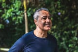 Hombre de mediana edad aprovecha el día soleado para caminar en parque al aire libre