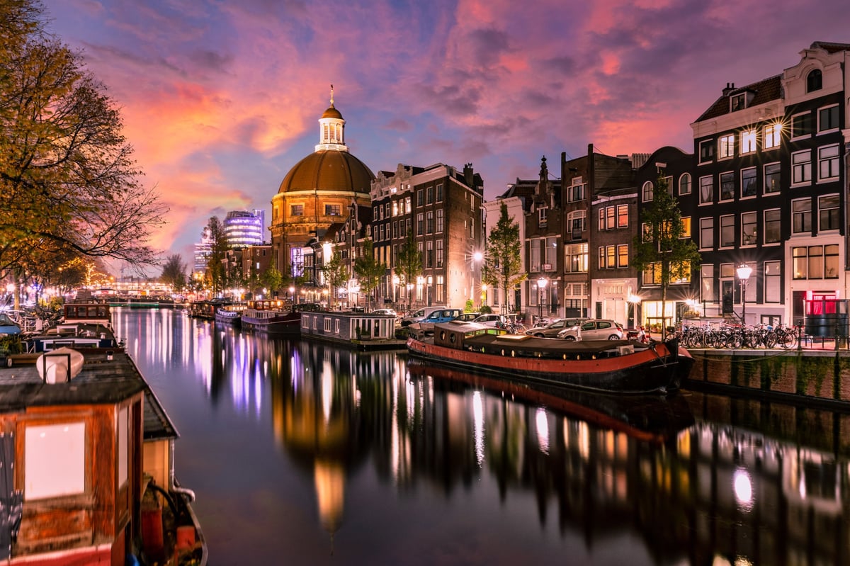 Scenic view of Amsterdam canal at sunset with historic buildings