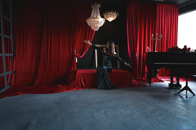 Young woman musician in elegant dress opening red curtains on stage with grand piano, chandelier, and roses