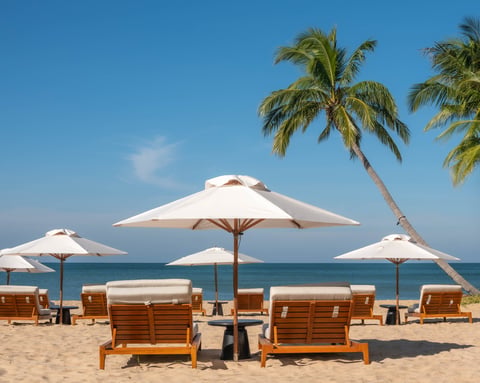 Tropical beach with wooden lounge chairs and white umbrellas