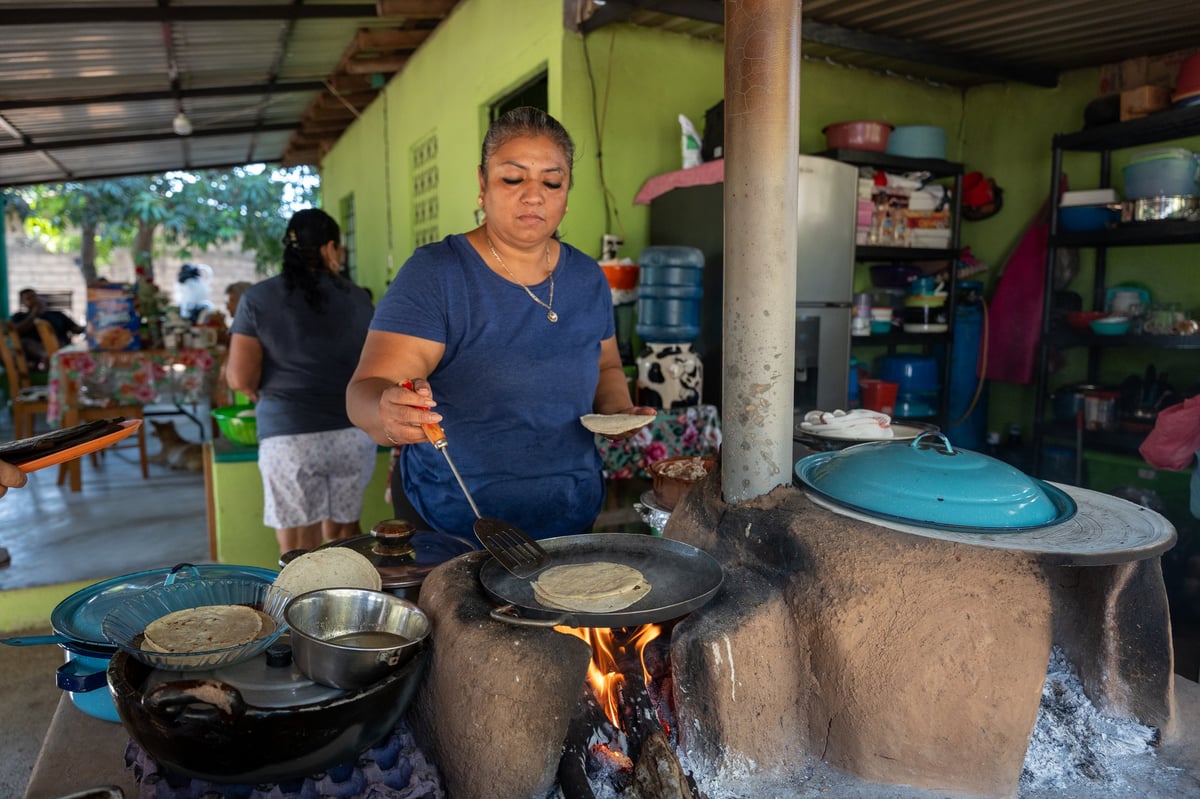 Mujer mexicana preparando tortillas en comal tradicional