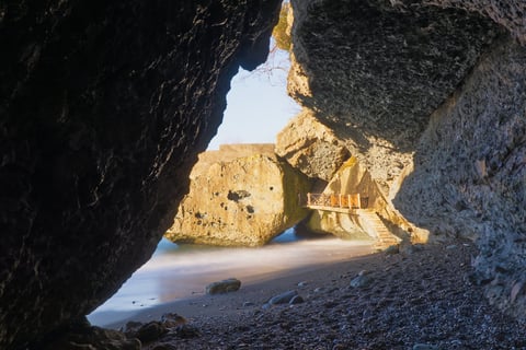 Cueva marina con playa rocosa soleada adentro efectos dorados