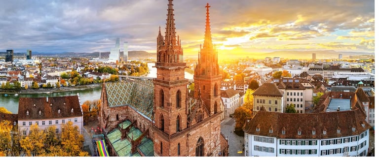 Aerial sunset view of a Gothic cathedral with twin spires overlooking a European city with river