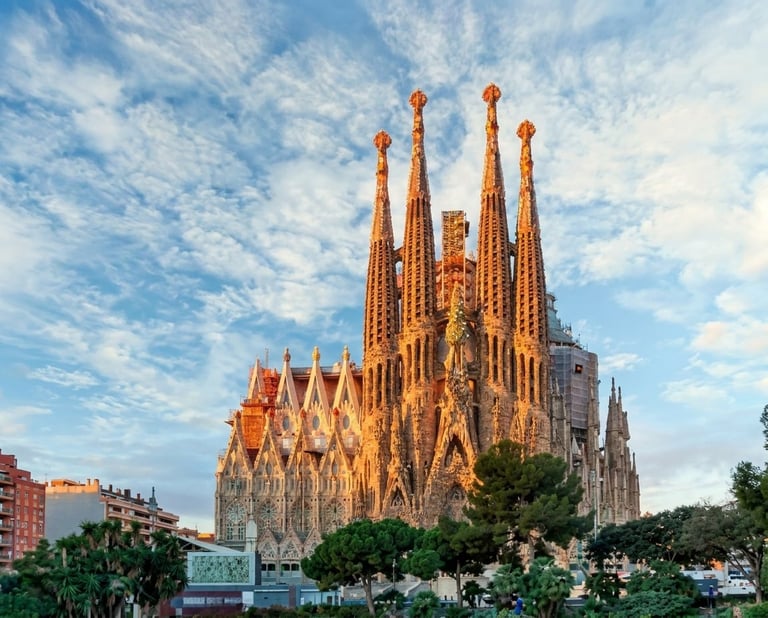 Sagrada Familia basilica in Barcelona with ornate spires against blue sky and clouds