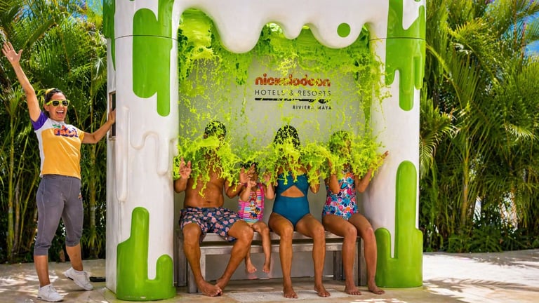 Grupo de niños posando en photo booth temático de Nickelodeon con fondo tropical