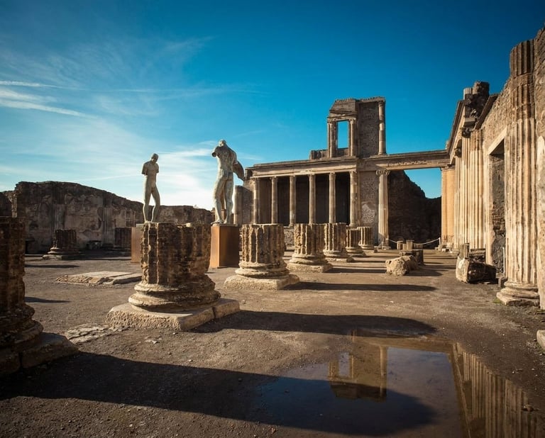 Ancient Roman ruins with columns and statues under blue sky, Pompeii archaeological site