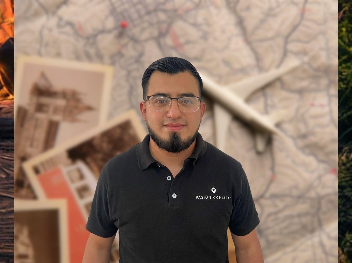 Man wearing glasses and black polo shirt standing indoors with framed artwork visible in blurred background