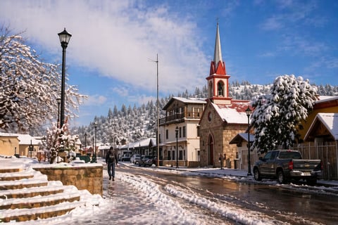 Snow-covered mountain village street with church steeple