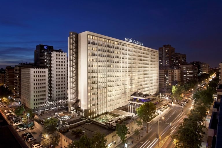 Edificio de oficinas iluminado al atardecer con rascacielos y calles de la ciudad