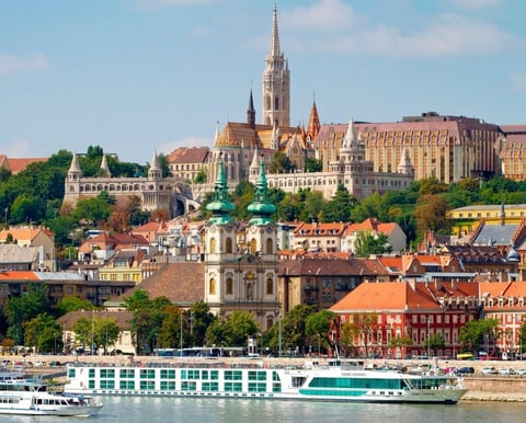 Panoramic view of Budapests riverfront with Matthias Church and river cruise ship on the Danube